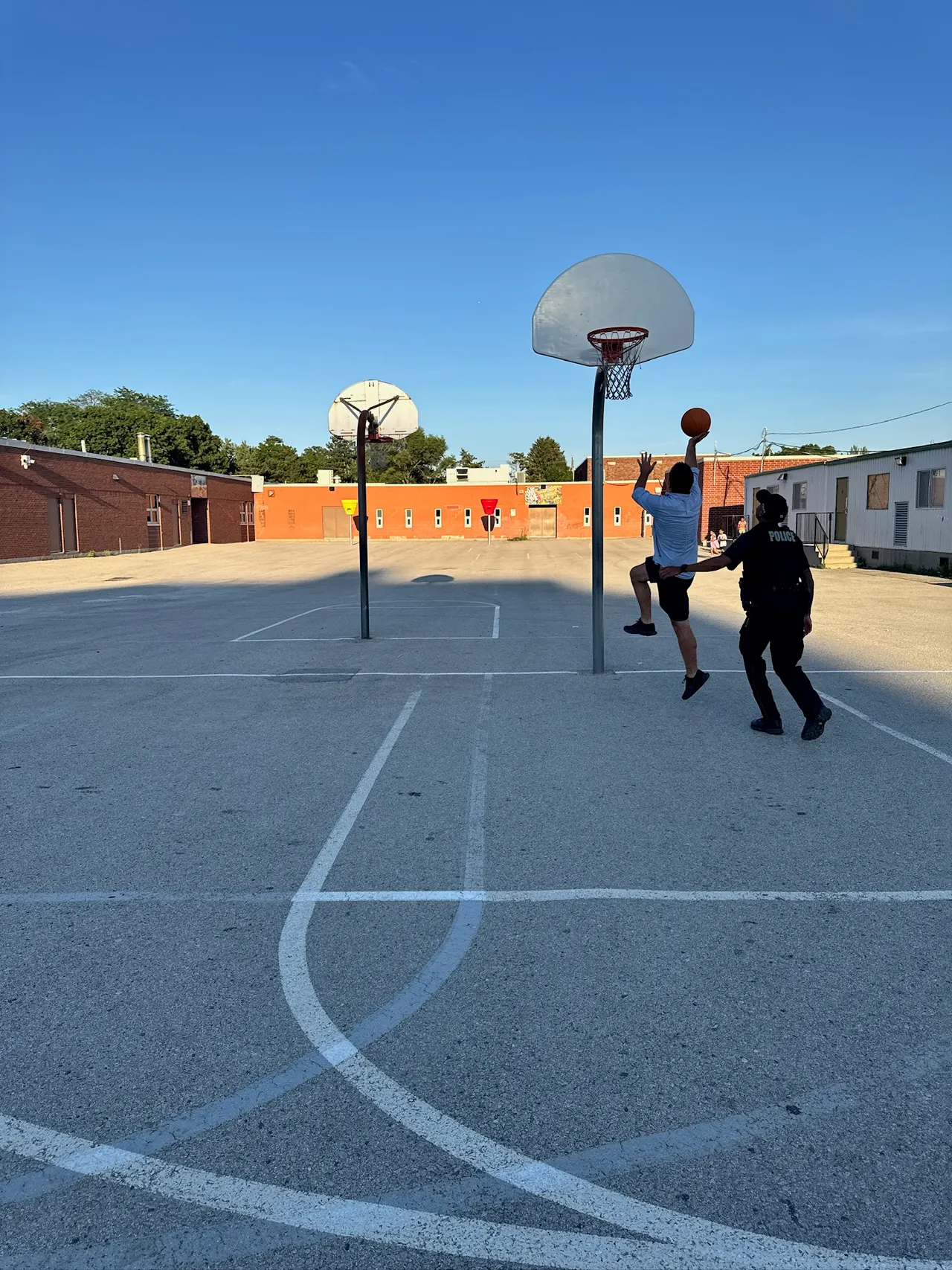 Children playing basketball on a neighbourhood outdoor court