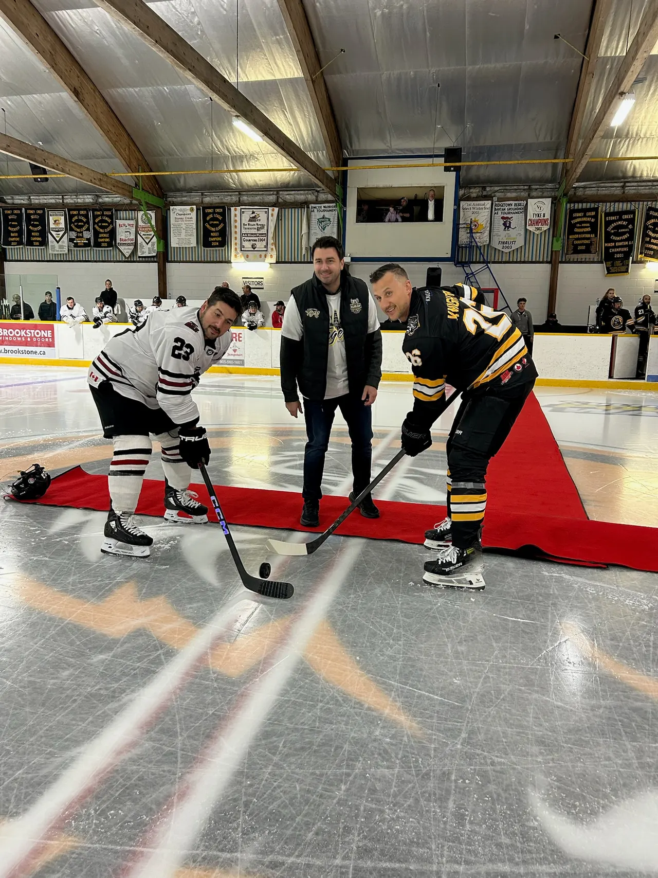 Ceremonial puck drop between two players at a minor hockey game
