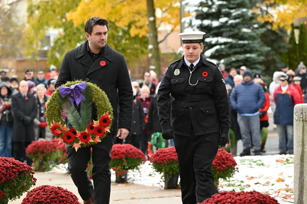 Matt Francis carrying a wreath in the Remembrance Day procession